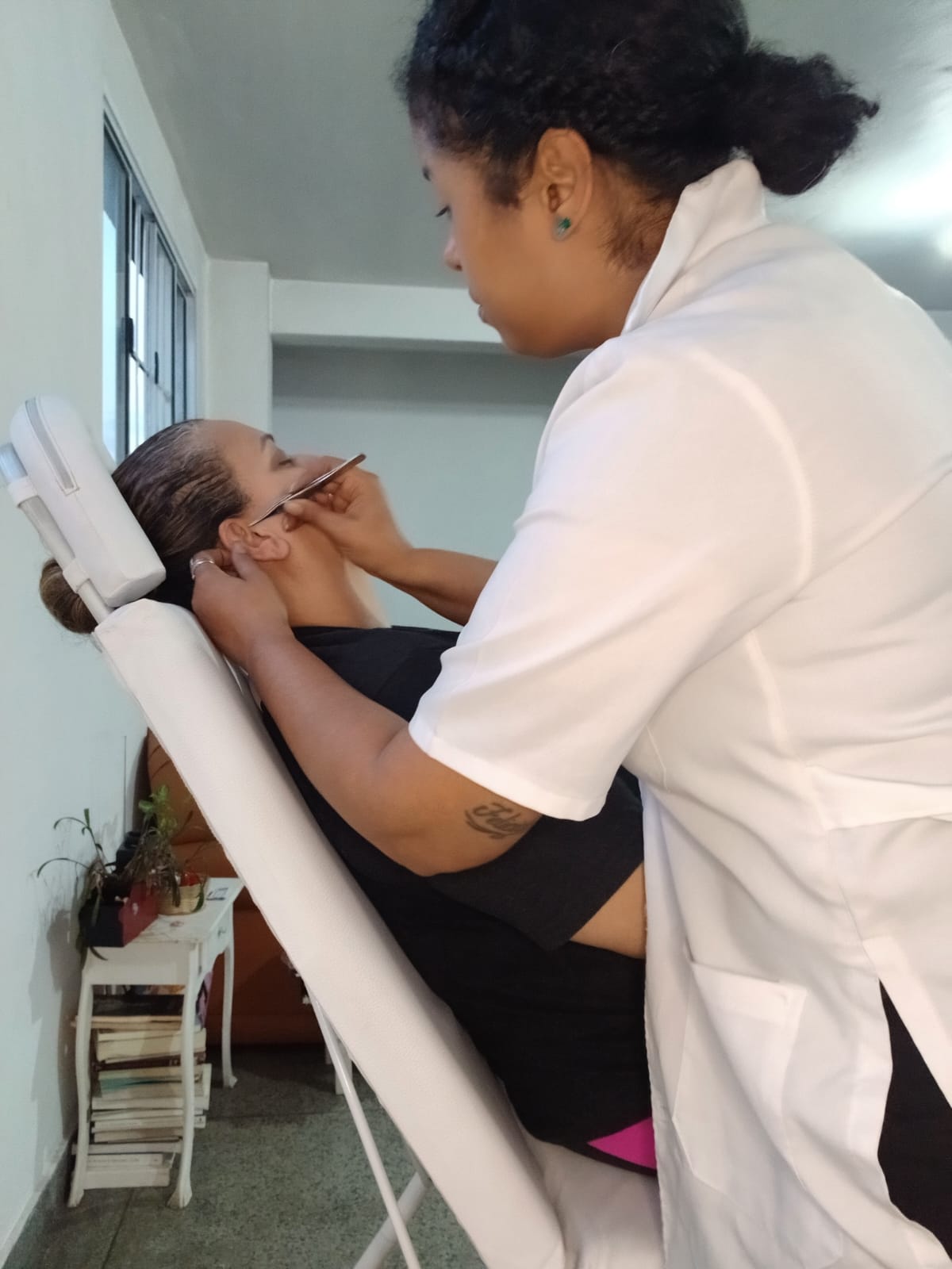 Georgea posicionando a orelha da paciente antes de aplicar os pontos