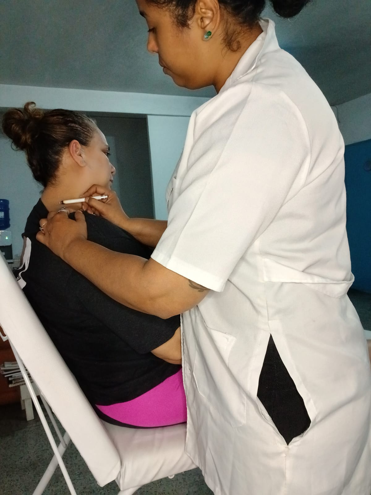 Georgea aplicando moxa na cervical da paciente sentada