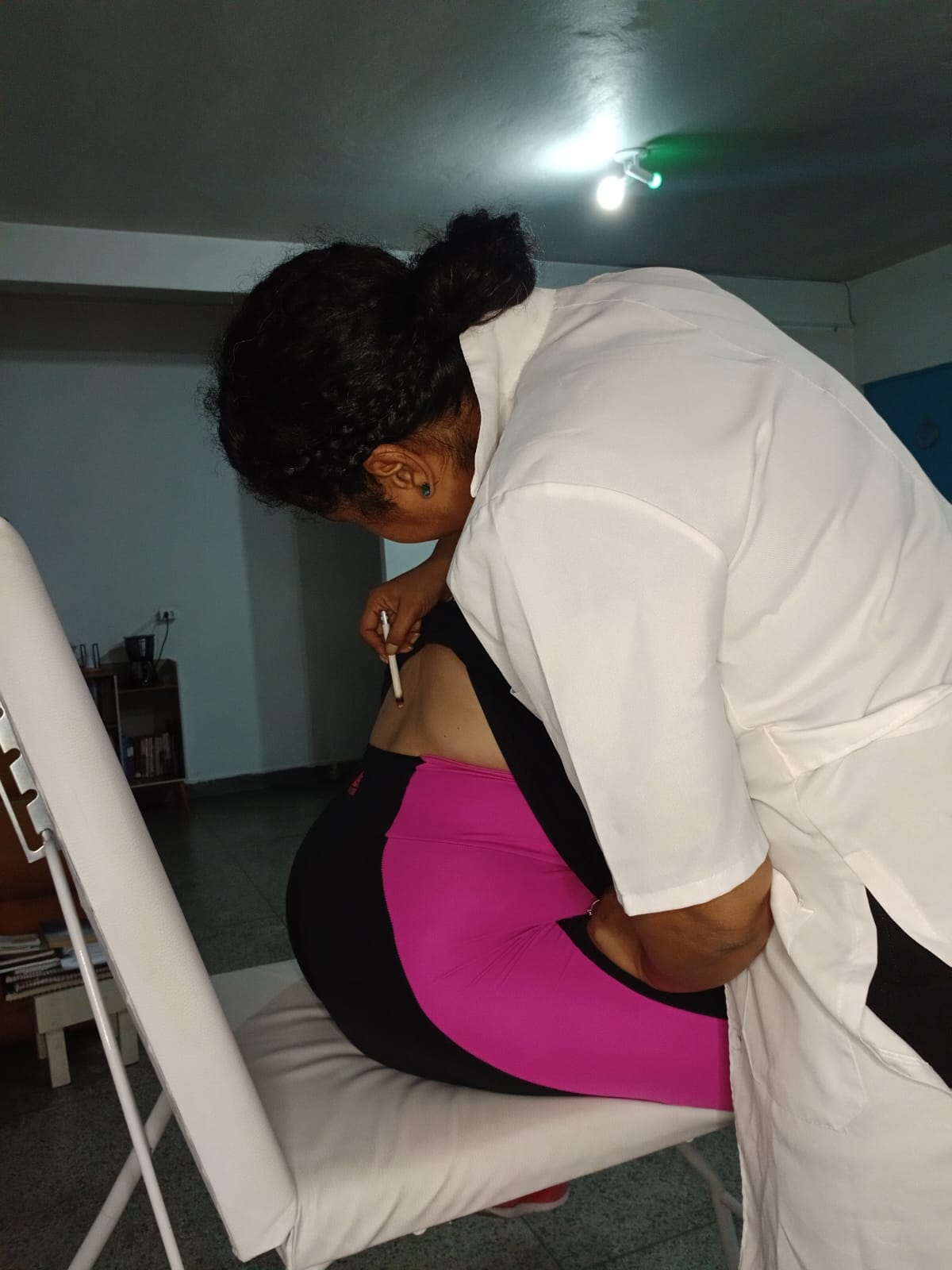 Georgea aplicando moxa ao longo das costas da paciente